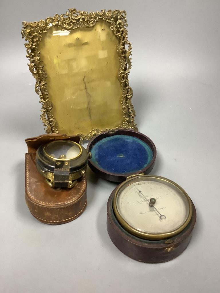 A pocket barometer, a compass, a 19th century desk stand and a photograph frame